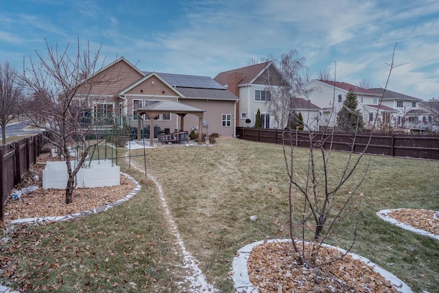 rear view of house featuring a gazebo and a lawn