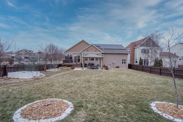 back of house featuring a gazebo, solar panels, a deck, and a yard