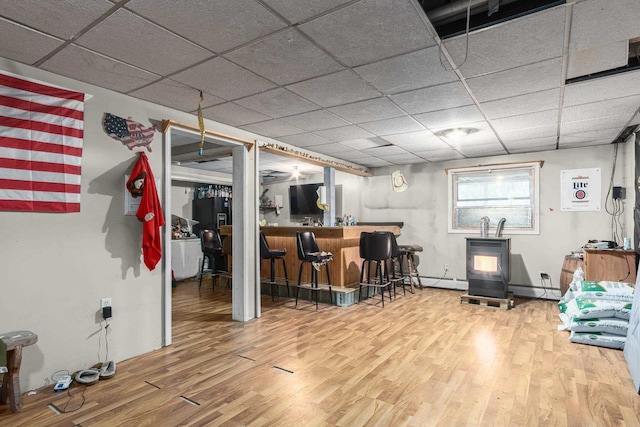 bar with hardwood / wood-style flooring, a paneled ceiling, and a baseboard radiator