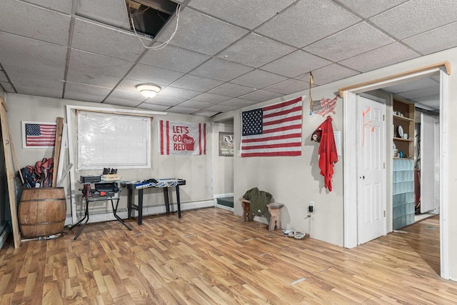 miscellaneous room featuring wood-type flooring and a paneled ceiling