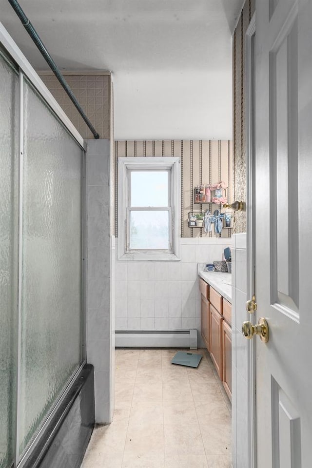 bathroom featuring vanity, tile patterned floors, tile walls, a baseboard radiator, and an enclosed shower