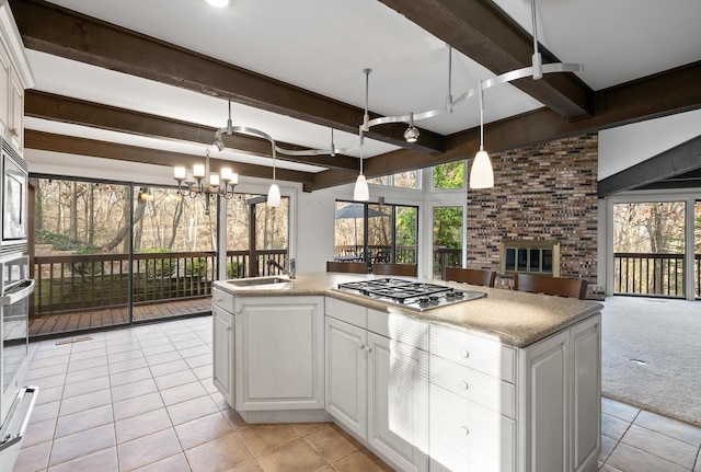 kitchen with a wealth of natural light, beamed ceiling, and white cabinets