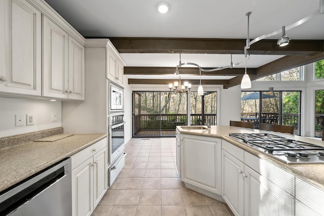 kitchen featuring beam ceiling, white cabinets, and appliances with stainless steel finishes