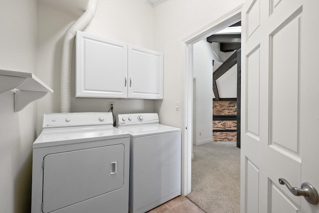 clothes washing area with washer and dryer, cabinets, and light carpet