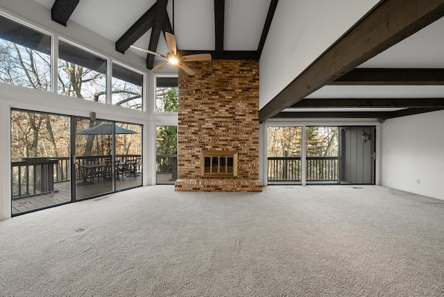 unfurnished living room featuring carpet flooring, a high ceiling, plenty of natural light, and ceiling fan