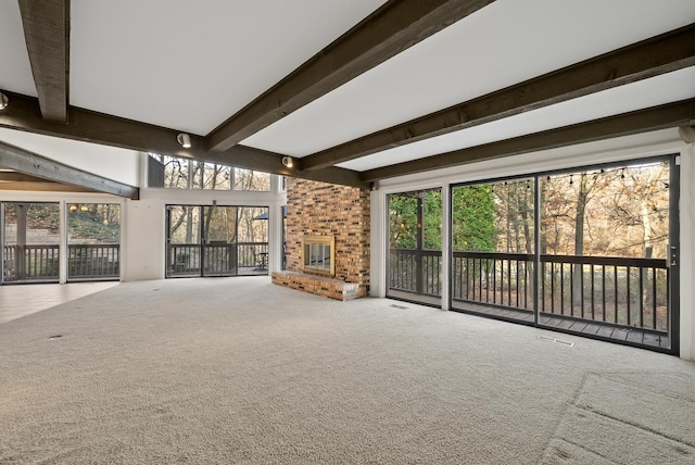 unfurnished living room with beamed ceiling and a healthy amount of sunlight