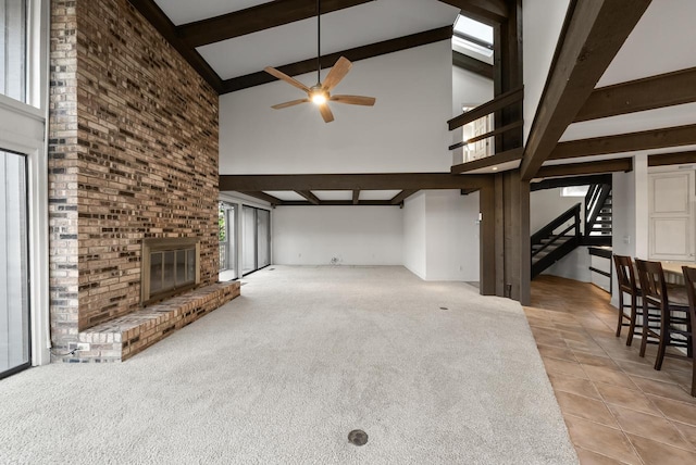 unfurnished living room featuring a brick fireplace, high vaulted ceiling, and a healthy amount of sunlight