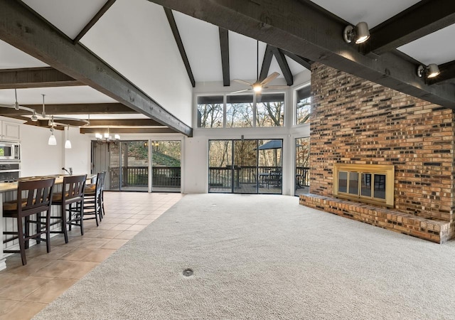 living room with beam ceiling, a wealth of natural light, a fireplace, and light tile patterned floors