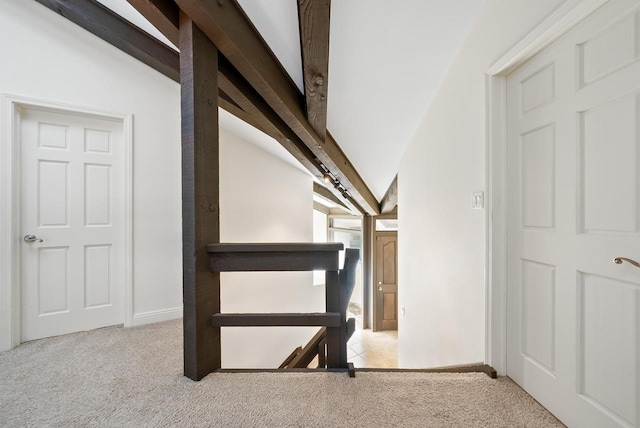 stairs with carpet flooring and lofted ceiling with beams