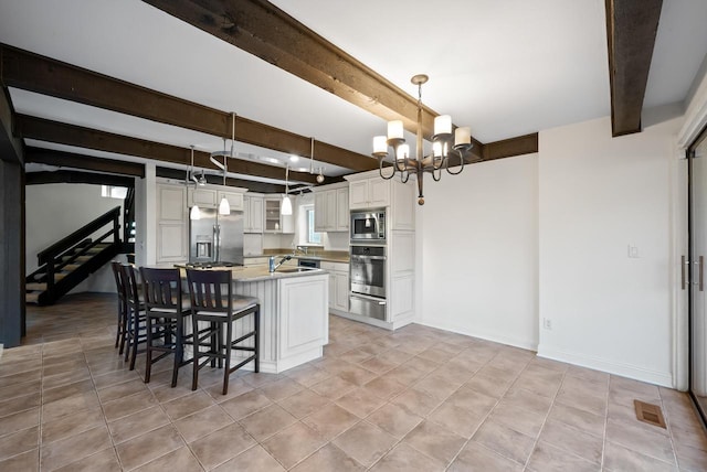 kitchen featuring pendant lighting, a center island, white cabinets, beamed ceiling, and stainless steel appliances