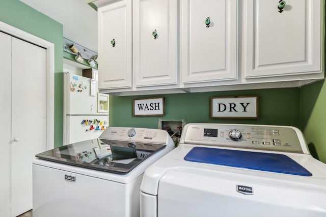 washroom with washer and dryer and cabinets