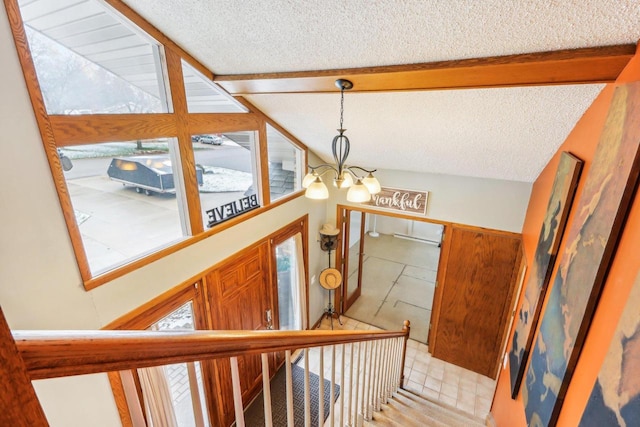 stairs featuring vaulted ceiling with beams, wood walls, a textured ceiling, and an inviting chandelier