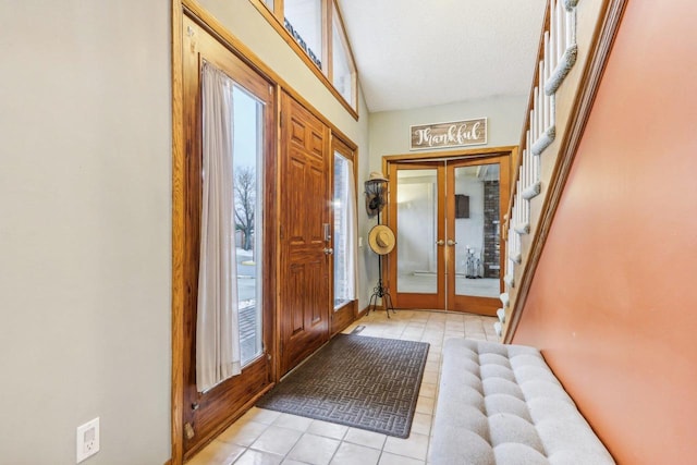 tiled foyer entrance with french doors, a textured ceiling, and vaulted ceiling