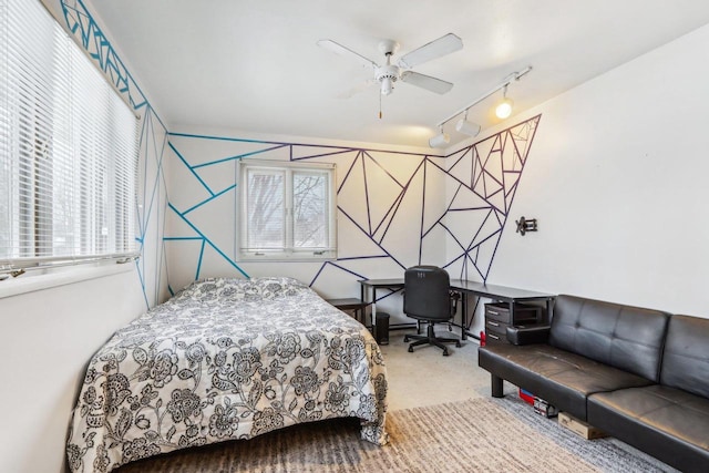 carpeted bedroom with ceiling fan and rail lighting