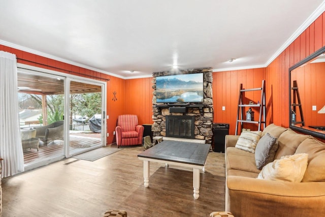 living room featuring hardwood / wood-style floors, ornamental molding, and a fireplace