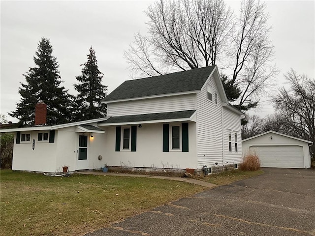 view of front of home with a garage, a front lawn, and an outdoor structure