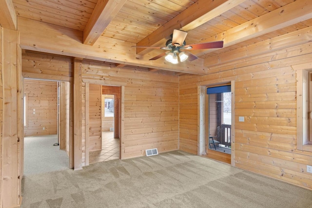 unfurnished bedroom featuring light carpet, multiple windows, and beamed ceiling