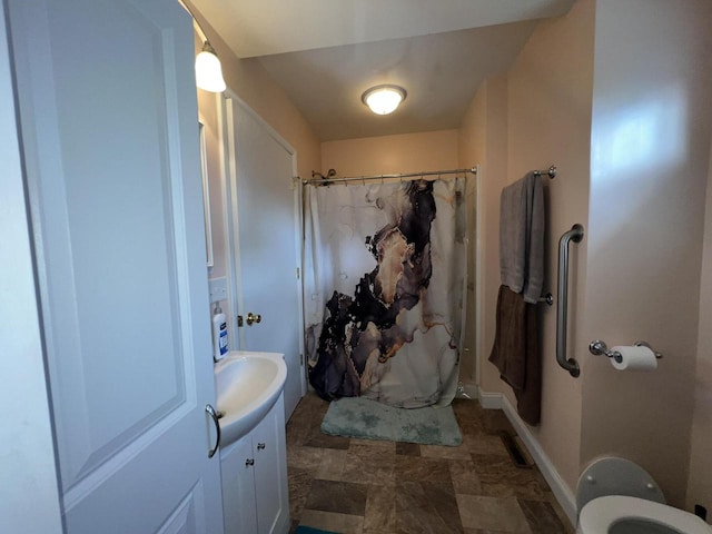 bathroom with vanity, toilet, and walk in shower