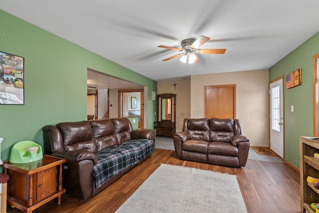 living room with ceiling fan and dark hardwood / wood-style flooring