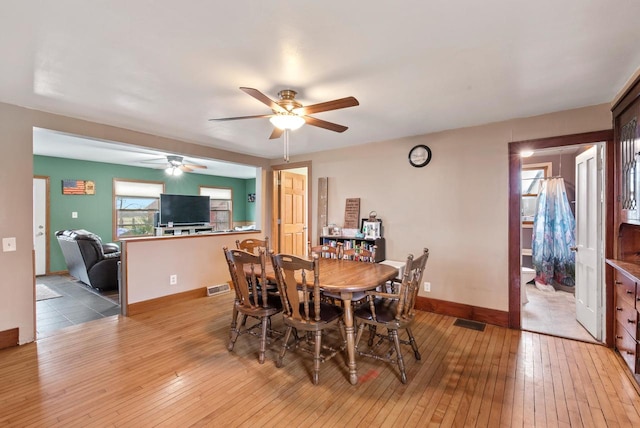 dining area with ceiling fan and light wood-type flooring