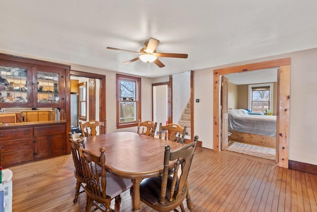 dining area with light hardwood / wood-style floors and ceiling fan