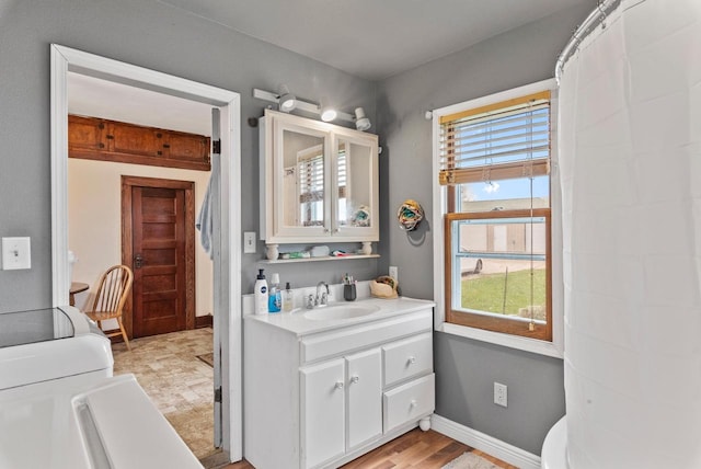 bathroom with wood-type flooring, vanity, toilet, and a healthy amount of sunlight