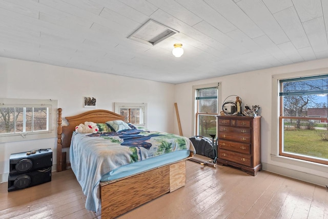 bedroom featuring multiple windows and light hardwood / wood-style flooring