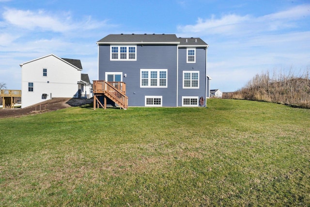 rear view of property featuring a wooden deck and a lawn