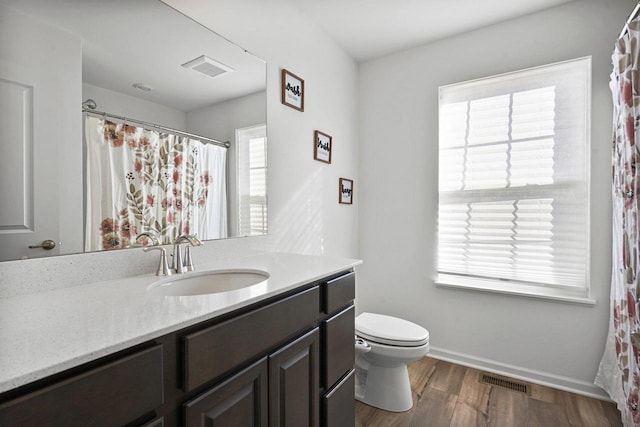 bathroom featuring wood-type flooring, vanity, and toilet