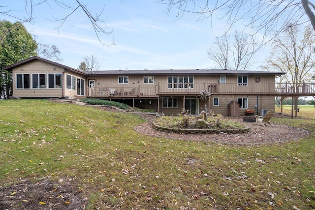 rear view of property featuring a wooden deck and a lawn