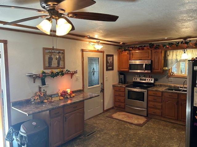 kitchen featuring ceiling fan, sink, stainless steel appliances, and a textured ceiling