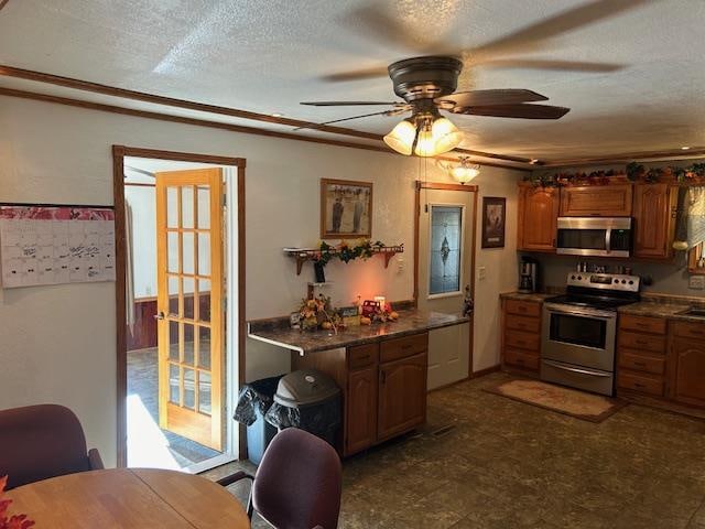 kitchen with ceiling fan, stainless steel appliances, and a textured ceiling