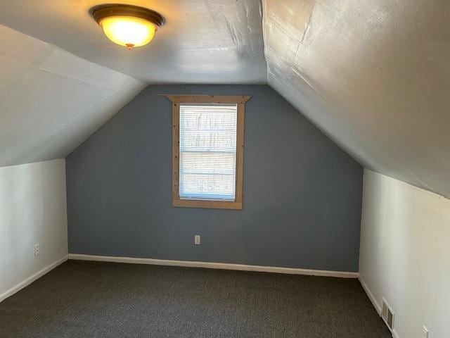 bonus room featuring lofted ceiling and dark colored carpet