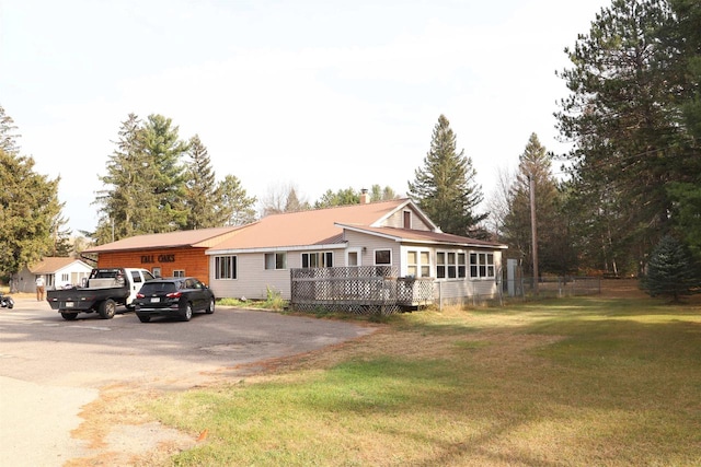 view of front of house featuring a front lawn and a deck