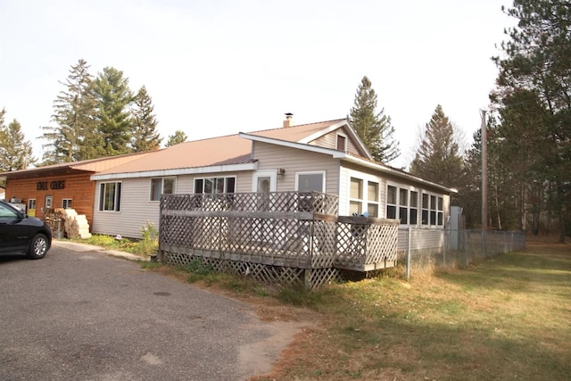 back of property with a lawn and a deck