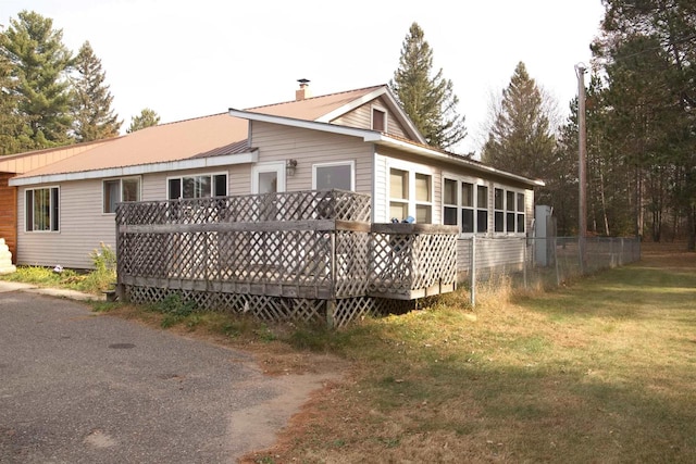 rear view of property with a lawn and a deck