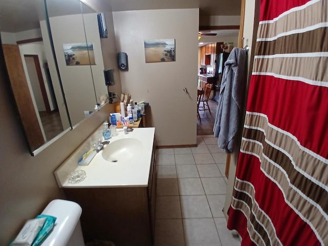 bathroom featuring tile patterned flooring, vanity, ceiling fan, and toilet