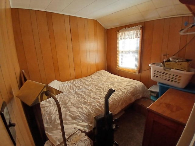 bedroom with wood walls and lofted ceiling