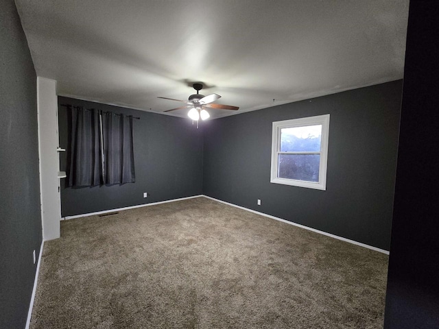 spare room featuring ceiling fan and carpet floors