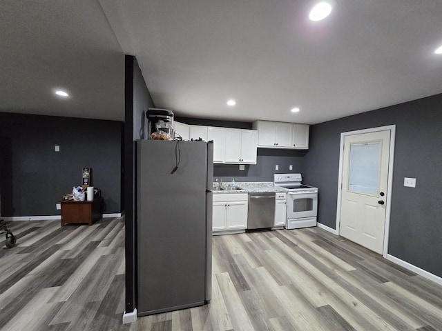 kitchen featuring appliances with stainless steel finishes, light hardwood / wood-style flooring, white cabinetry, and sink