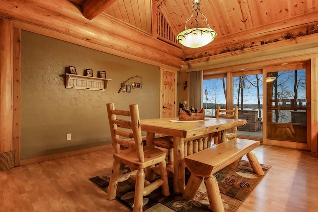 dining area featuring beamed ceiling, wood-type flooring, and wooden ceiling