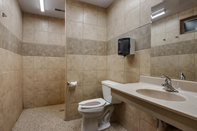 bathroom with sink, tile walls, and toilet