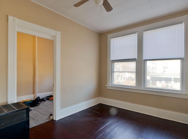 empty room featuring ceiling fan, dark hardwood / wood-style floors, and ornamental molding