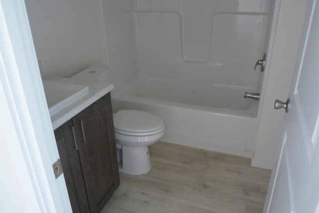 full bathroom with shower / tub combination, toilet, vanity, and hardwood / wood-style flooring