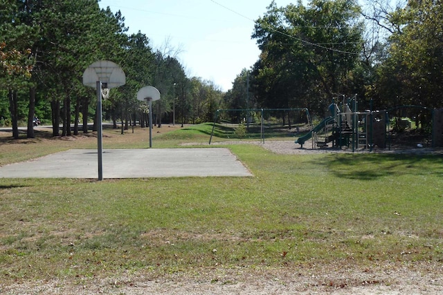 view of basketball court featuring a playground and a yard