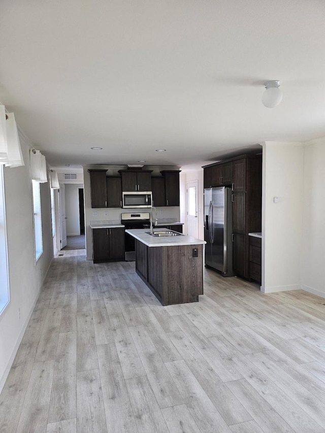 S13041 Shifflet Rd Unit 128, Spring Green, WI 53588 - kitchen featuring appliances with stainless steel finishes, an island with sink, light wood-type flooring, light countertops, and a sink