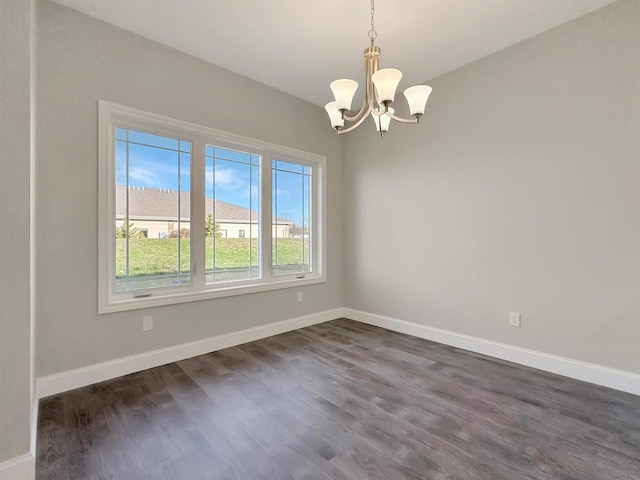 unfurnished room with a notable chandelier and dark hardwood / wood-style floors