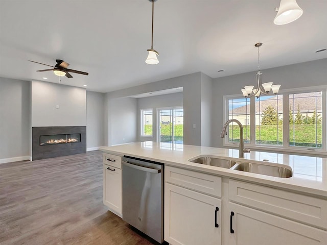 kitchen featuring white cabinetry, dishwasher, sink, pendant lighting, and light wood-type flooring