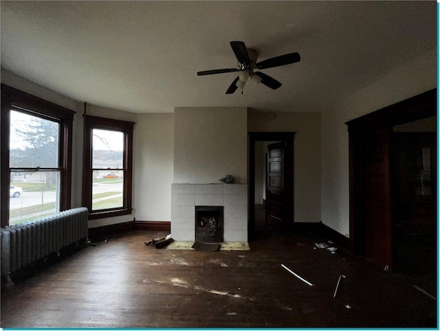 unfurnished living room with a fireplace, dark hardwood / wood-style floors, and ceiling fan