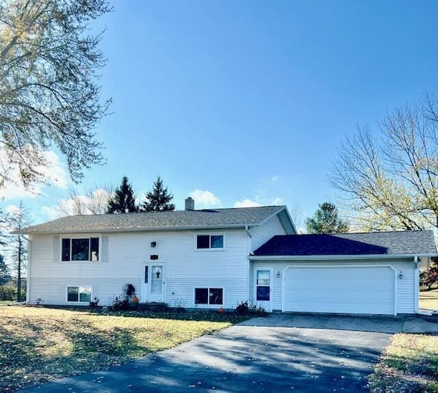 split foyer home with a garage and a front yard